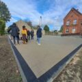 Zdjęcie przedstawia teren wyłożony kostką wokół przedszkola w Przemęcie. Na fotografii znajdują się również członkowie Komisji Stałych Rady Gminy Przemęt.