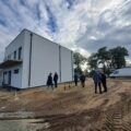 Zdjęcie przedstawia teren wokół stadionu w Buczu. Na zdjęciu uchwycono bok stadionu. Na fotografii znajdują się również członkowie Komisji Stałych Rady Gminy Przemęt.