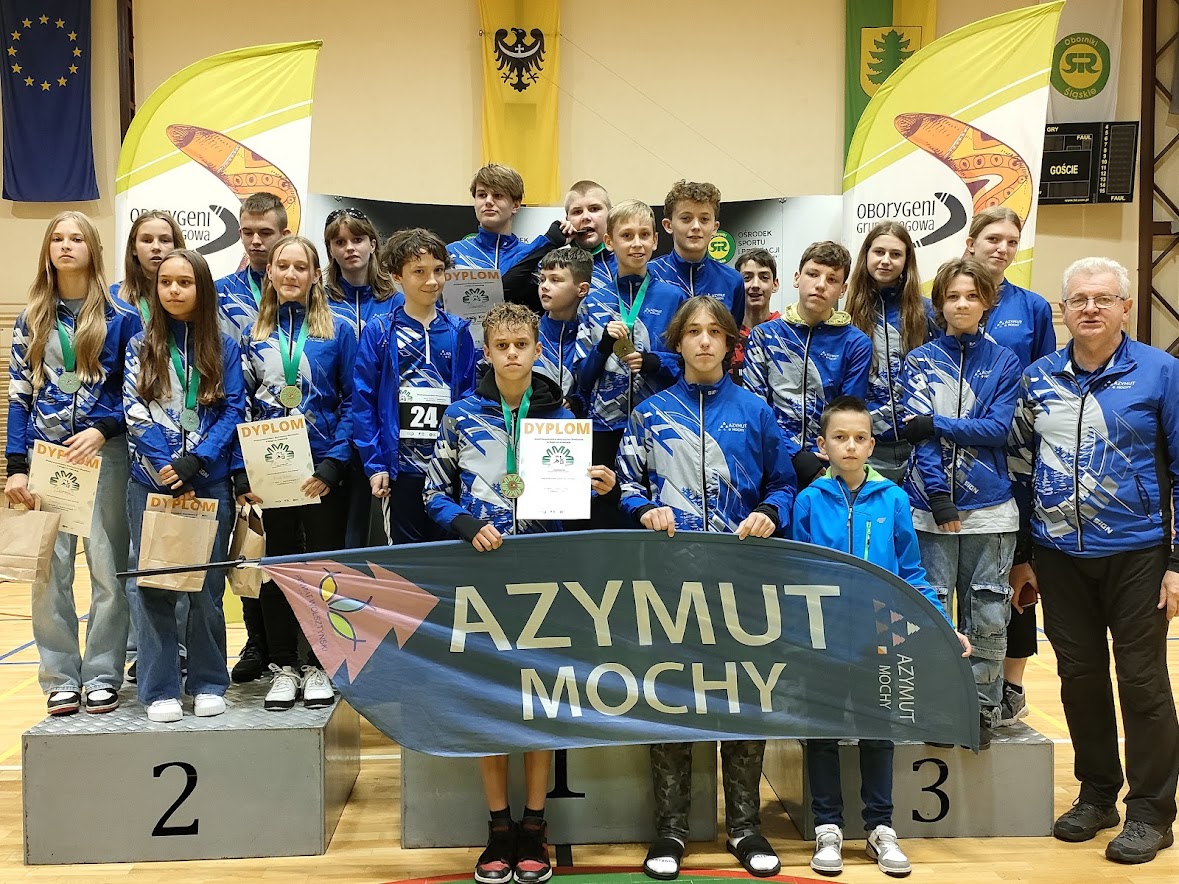 Wspólne zdjęcie drużyny HKS Azymut Mochy. Niektóre osoby pozują z dyplomami i medalami.