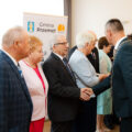 Na zdjęciu wójt składający gratulacje jubilatom poprzez uścisk dłoni.