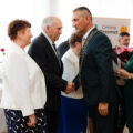 Na zdjęciu wójt składający gratulacje jubilatom poprzez uścisk dłoni.