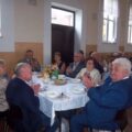 Zdjęcie przedstawia klaszczące pary siedzące przy stołach w sali w Buczu.