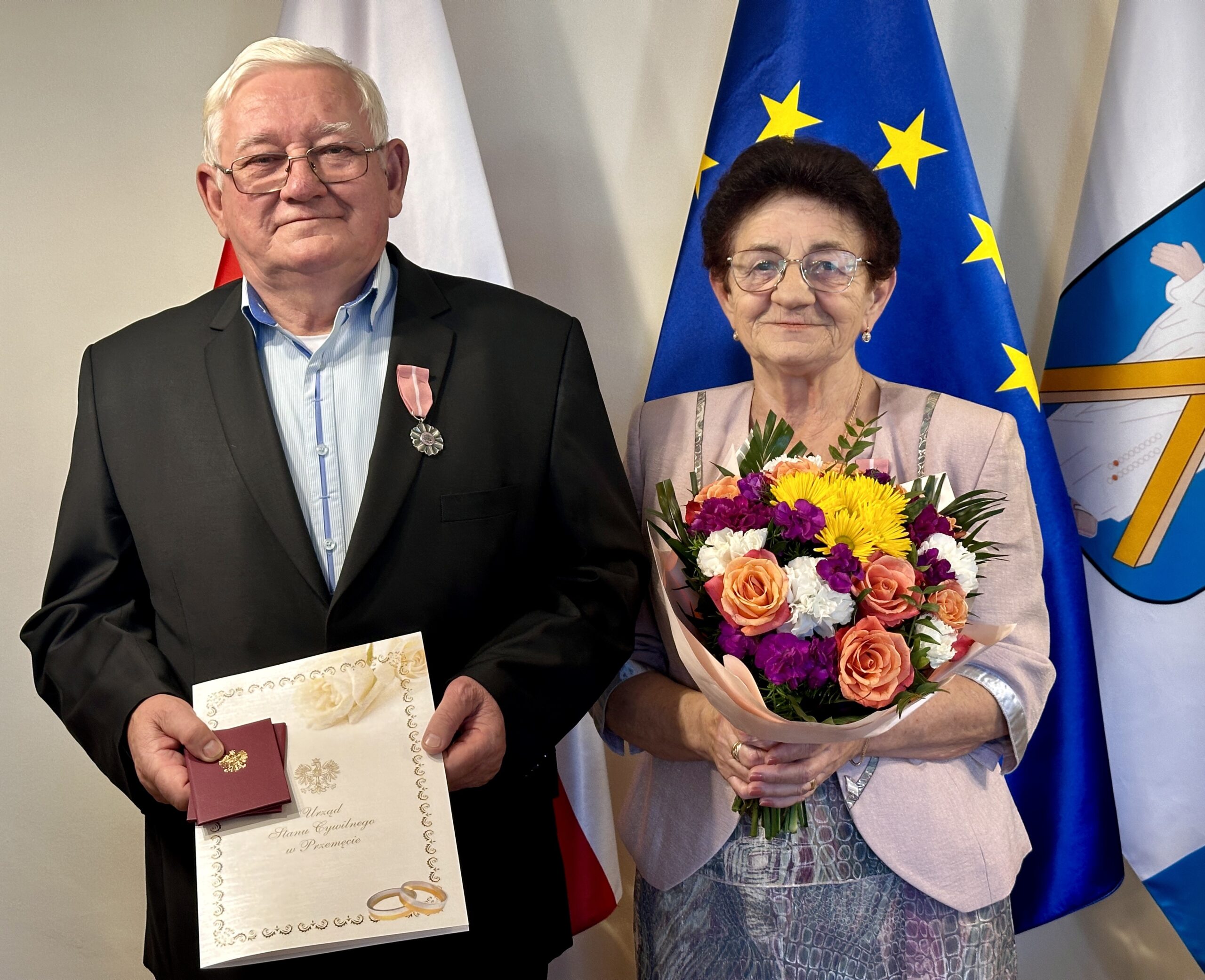 Na zdjęciu Państwo Rzonsowscy z bukietem kwiatów oraz listem gratulacyjnym.
