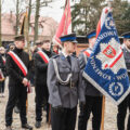Zdjęcie przedstawia delegacje ze sztandarami, które stoją przed kościołem.