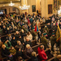 Zdjęcie ukazuje ludzi zebranych na uroczystości w kościele. Wejście delegacji.