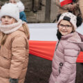 Zdjęcie przedstawia dzieci trzymające flagę Polski.