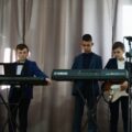 Trzech chłopców gra na instrumentach
