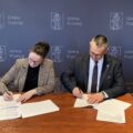 Zdjęcie przedstawia Wójta Gminy Przemęt oraz przedstawiciela firmy brukarskiej - HC firma usługowo-handlowa Henryk Cieplik. Osoby ww. podpisują umowę na tle ścianki Gmina Przemęt.