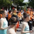 Na pierwszym planie mażoretki, w tle orkiestra.