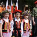 Delegacja dzieci w ludowych strojach pozuje do zdjęcia