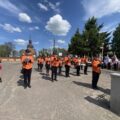 Orkiestra Dęta gra na instrumentach - w tle kościół
