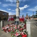 Pomnik, a pod nim kwiaty i znicze