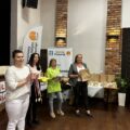 Na zdjęciu Przewodnicząca Rady Gminy Przemęt Monika Maćkowiak, która trzyma w ręce medale dla uczestników turnieju, Pani Patrycja Pabich z Wydziału Oświaty, Promocji, Turystyki i Sportu, która trzyma kamizelki odblaskowe, Dyrektor Przedszkola w Nowej Wsi Pani Alina Piotrowska, która trzyma dyplomy oraz Dyrektor Przedszkola w Przemęcie Pani Elżbieta Grygiel-Tórz, która trzyma nagrody rzeczowe. W tle roll up Gmina Przemęt oraz winder Honorowy Patronat Wójta Gminy Przemęt.