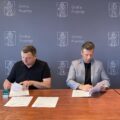 Fotografia przedstawia moment podpisywania umowy między zastępcą wójta Gminy Przemęt, a Panem Sławomirem Białasikiem. W tle ścianka z napisem Gmina Przemęt i herbem gminy, który przedstawia postać św. Andrzeja.
