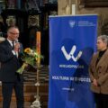 Wójt wręcza kwiaty pani profesor.