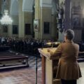 Zdjęcie zza pleców wykładowczyni, w tle publiczność.