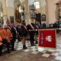Poczet sztandarowy składa hołd pod ołtarzem.