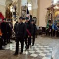 Poczet sztandarowy składa hołd pod ołtarzem.