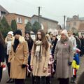 Uczestnicy wydarzenia składają kwiaty pod pomnikiem.