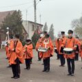Orkiestra dęta gra przy pomniku.