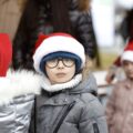 Chłopiec w świątecznej czapce pozuje do zdjęcia.