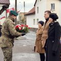 Na zdjęciu żołnierz odbiera wiązankę kwiatów od delegacji.