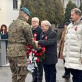 Na zdjęciu żołnierz odbiera wiązankę kwiatów od delegacji.