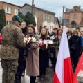 Na zdjęciu żołnierz odbiera wiązankę kwiatów od delegacji.