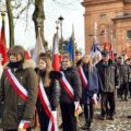 Na zdjęciu poczty sztandarowe stojące w rzędzie na zewnątrz.