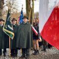 Na zdjęciu poczty sztandarowe stojące w rzędzie na zewnątrz.