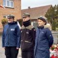 Na zdjęciu trójka harcerzy stoi przed pomnikiem na rynku.