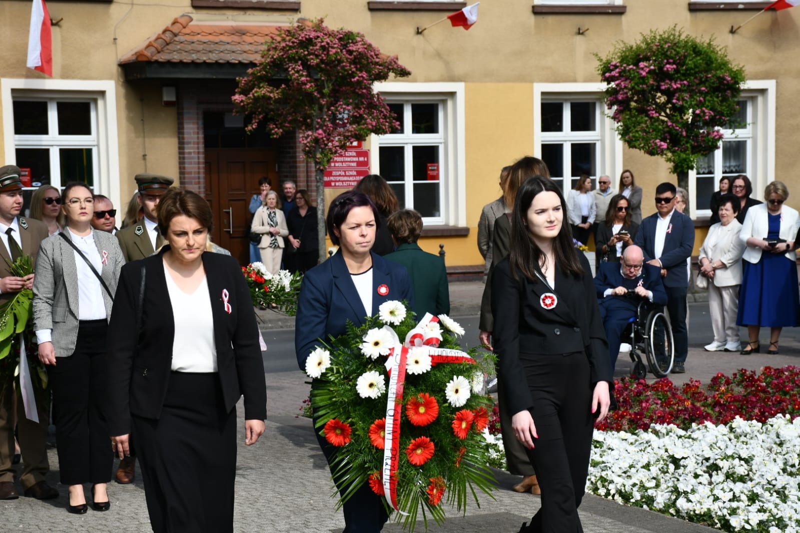 Na fotografii widoczna delegacja z gminy Przemęt, która składała się z pani Bernadety Golińskiej - radnej rady gminy Przemęt oraz dwóch pracownic z urzędu gminy Przemęt. Zdjęcie przedstawia moment składania przez delegację wiązanki.