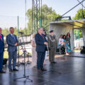 Na fotografii wicemarszałek Krzysztof Grabowski, który przemawia podczas wydarzenia. W tle wójt, minister Szczepański a także inne osoby.
