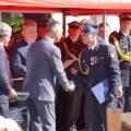 Na fotografii wójt gminy Przemęt składa gratulacje kpt. Damianowi Glapiakowi. W tle widoczni są strażacy oraz przedstawiciele władz samorządowych.