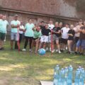 Na zdjęciu jedna z drużyn podczas wykonywania konkurencji polegającej na zbiciu piłką butelek wody.