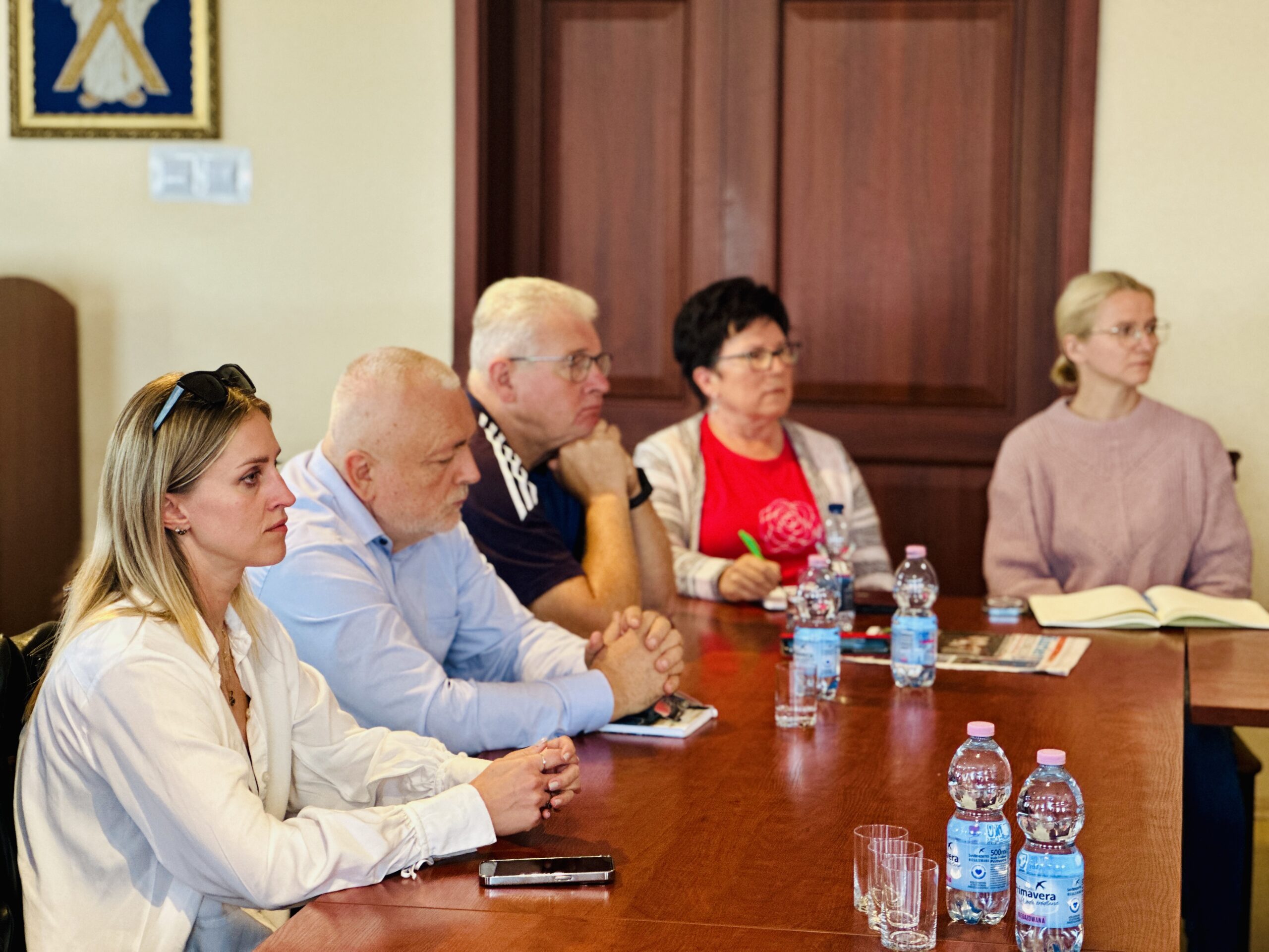 Na fotografii przedstawiciele organizacji pozarządowych siedzą na sali sesyjnej podczas spotkania.