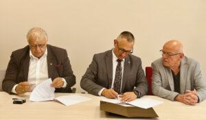 Na fotografii wójt i dyrektor Karol Mońko podczas podpisywania umowy. Na zdjęciu także dr Stanisław Wyrzykowski.