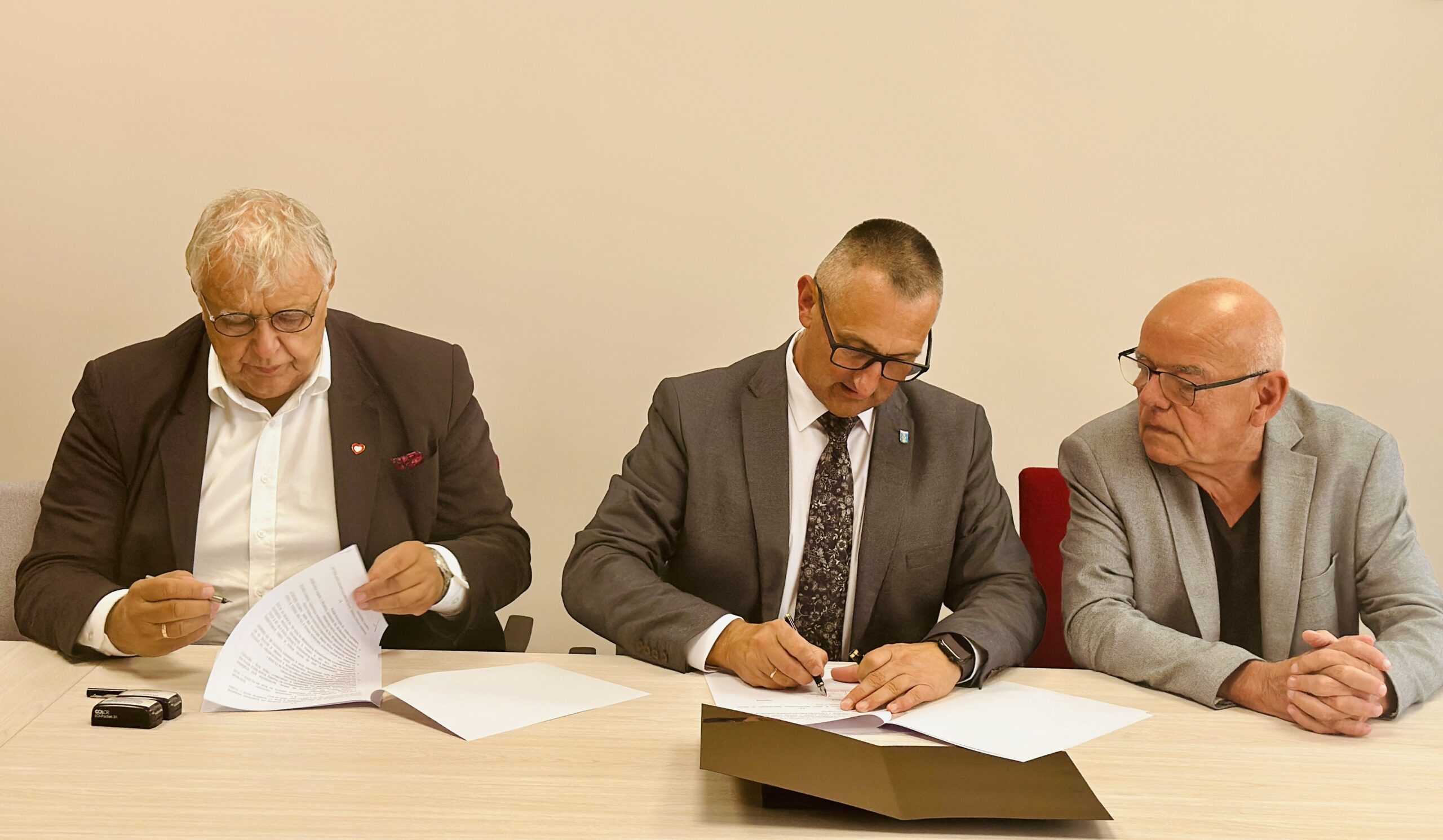 Na fotografii wójt i dyrektor Karol Mońko podczas podpisywania umowy. Na zdjęciu także dr Stanisław Wyrzykowski.