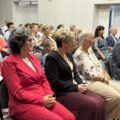 Na fotografii widoczni są seniorzy siedzący w sali podczas wykładu.