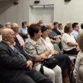 Na fotografii widoczni są seniorzy siedzący w sali podczas wykładu.