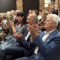 Na fotografii widoczni są seniorzy siedzący w sali podczas wykładu.