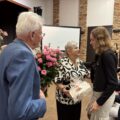 Na zdjęciu pani Krystyna Klawinska i jeden z seniorów wręczają prof. UAM dr hab. Sylwii Jaskulskiej bukiet kwiatów i upominek.