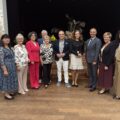 Grupowe zdjęcie, na którym znajdują się m.in.: wójt gminy, p.o. dyrektora Agnieszka Klugiewicz, pani Krystyna Klawinka wraz z przedstawicielami seniorów, a także prof. UAM dr hab. Sylwia Jaskulska i dr Mirosław Radoła. W tle scena.