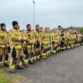 Na fotografii strażacy ustawieni w rzędzie.
