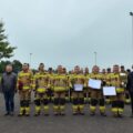 Na zdjęciu strażacy z jednostki OSP Bucz. Prezes jednostki pozuje z dużym pucharem, a inni strażacy z czekiem i dyplomem. Na fotografii widoczni są również kpt. Damian Glapiak oraz wójt gminy Siedlec.