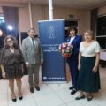 Na zdjęciu osoby należące do koła w Osłoninie oraz radna gminy Joanna Koziołek, która pozuje z bukietem kwiatów. Na zdjęciu widoczny także roll-up informujący o honorowym patronacie wójta.