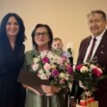 Na fotografii Patrycja Pabich, Mirosława Jakubowska oraz Robert Szwed. Pan Robert i Pani Mirosława pozują z bukietami kwiatów.