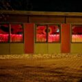 Na zdjęciu znajduje się budynek przedszkola w Buczu, a w jego oknach widać czerwone światło.