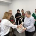 Na zdjęciu widoczna seniorka z Dziennego Domu Pomocy w Błotnicy, która wręcza kartki z życzeniami pracownicom GOPS-u.