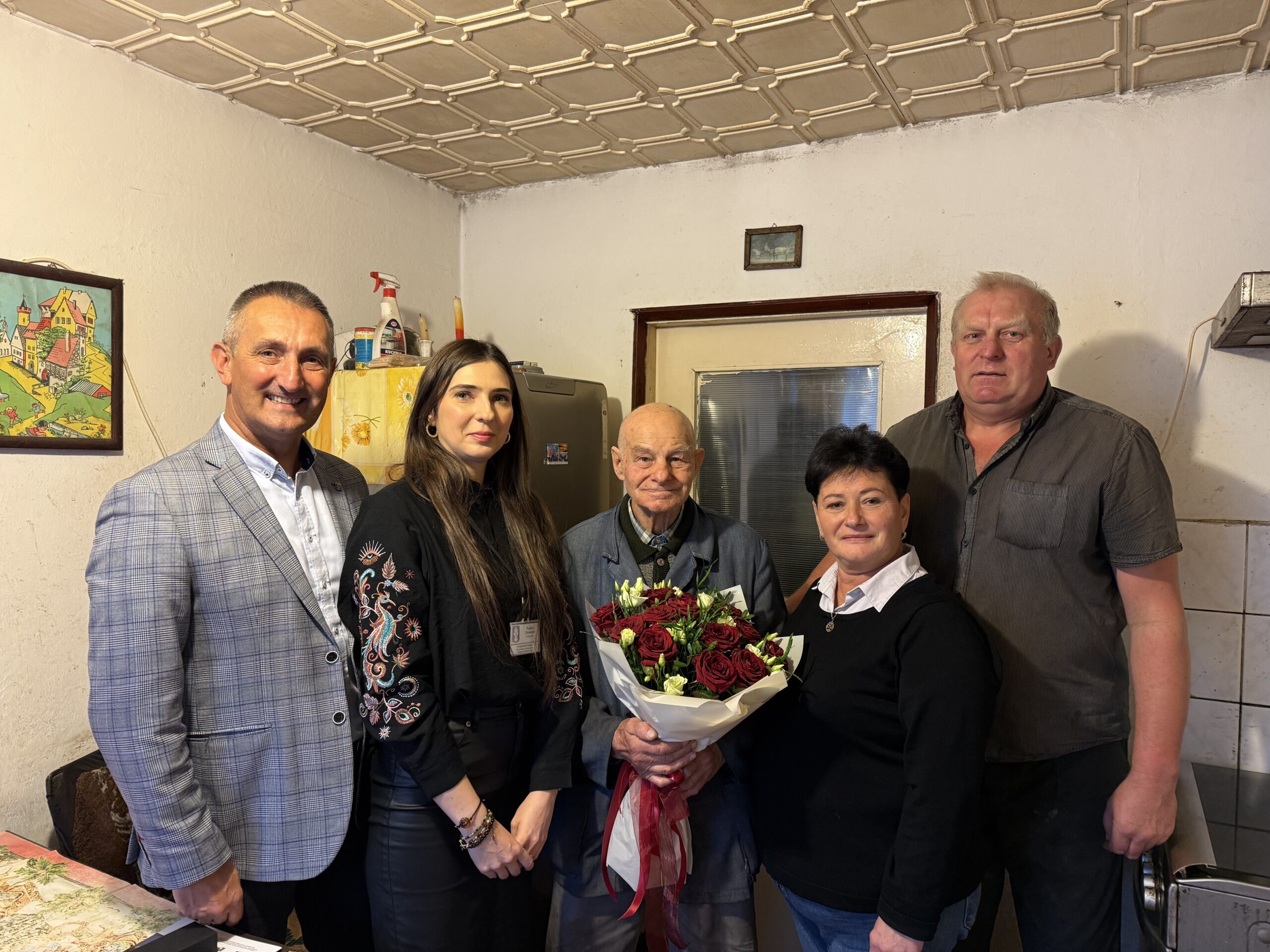 Na zdjęciu wójt gminy Przemęt Janusz Frąckowiak, Natalia Chomska z Urzędu Stanu Cywilnego oraz sołtys Kluczewa Jolanta Skoracka wraz z jubilatem Kazimierzem Malcherkiem i jego synem. Jubilat pozuje z bukietem kwiatów.